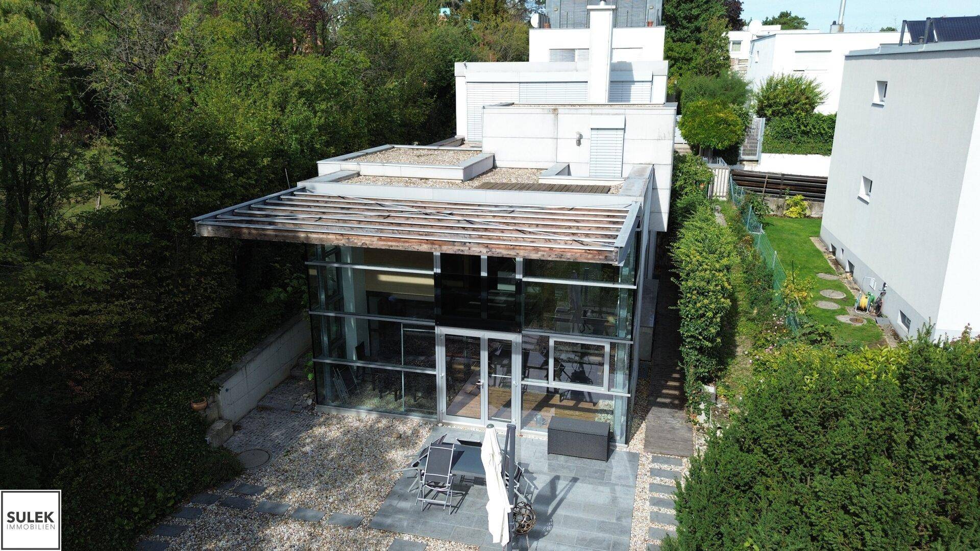 Vogelperspektive des Hauses mit großzügigem Garten, Terrasse und moderner Architektur, sehr ansprechend.