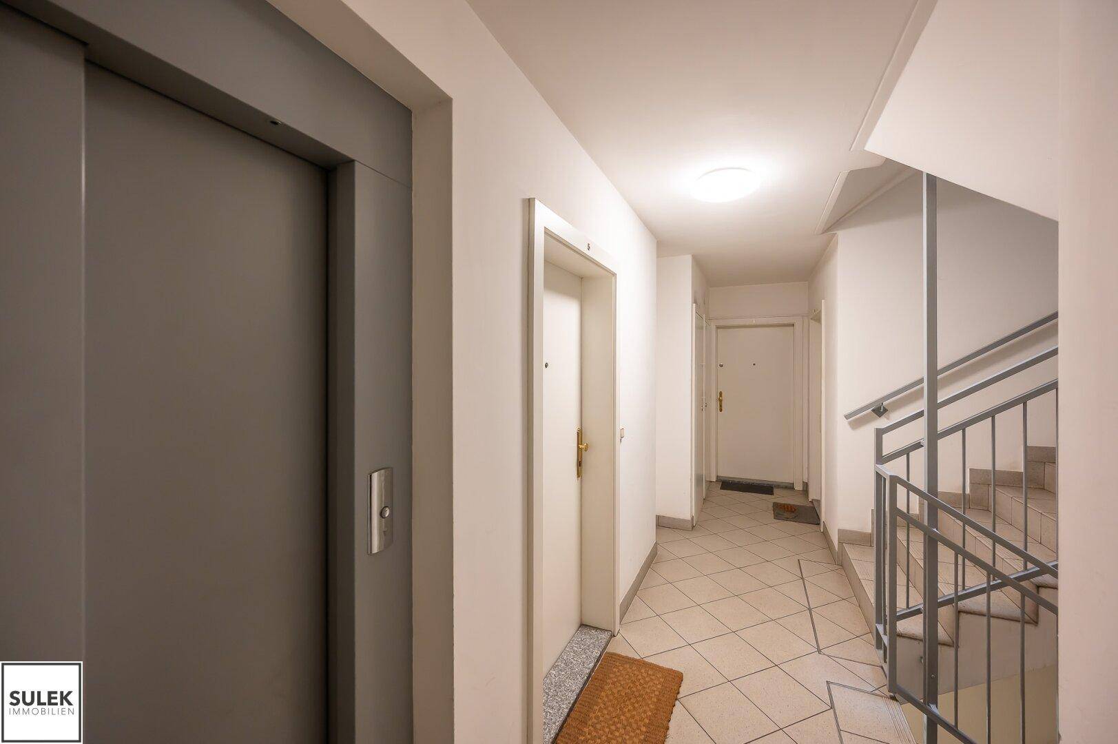 Heller Hausflur mit Aufzug und Treppenhauszugang zu den Wohnungen.