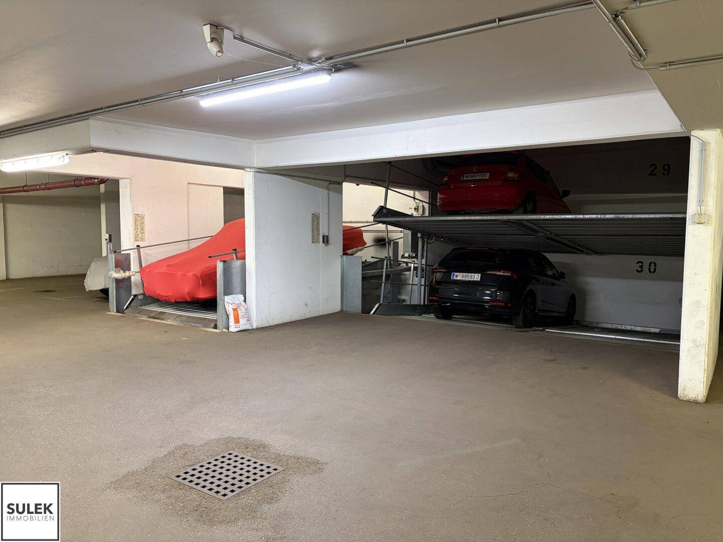 Geräumige Tiefgarage mit mehreren Doppelparker-Stellplätzen und Betonboden.