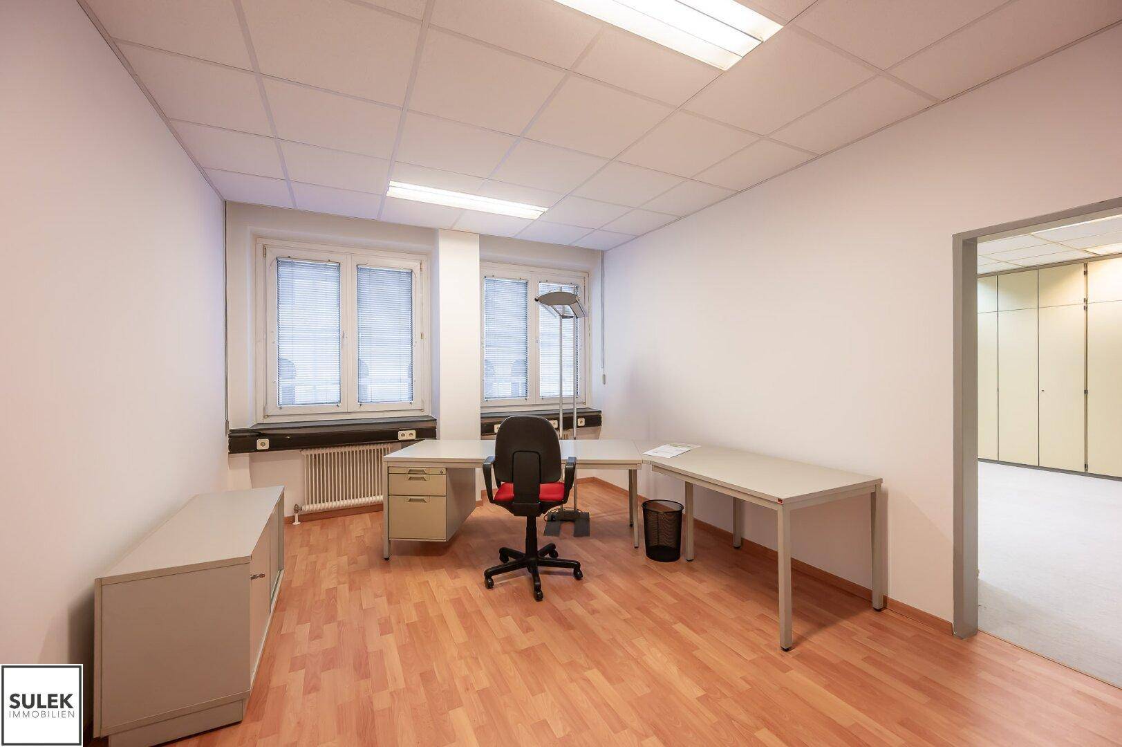 Büro mit Schreibtisch, Bürostuhl und Schränken, bereit für neue Mieter.