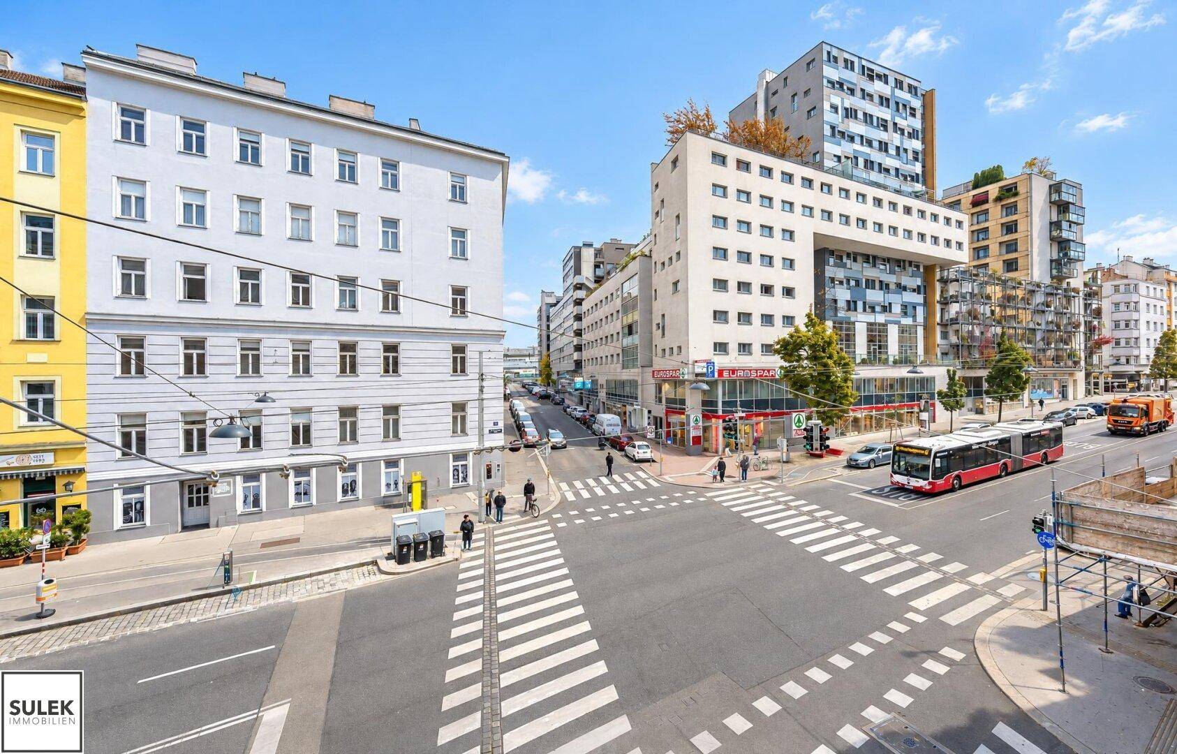 Belebtes Stadtviertel mit modernen Gebäuden, Geschäften und öffentlichen Verkehrsmitteln.