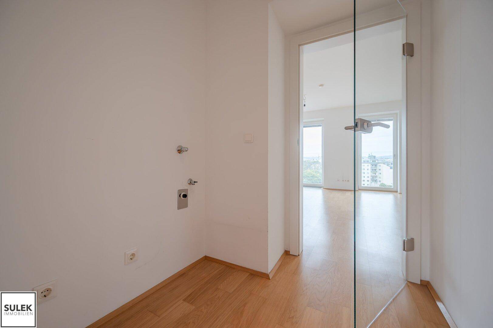 Hauswirtschaftsraum mit Anschlüssen für Waschmaschine und Trockner, mit Glas-Schwingtür.