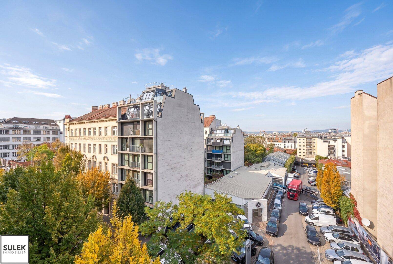 Weitläufiger Blick über die Stadt mit verschiedenen Gebäuden und herbstlichen Bäumen.