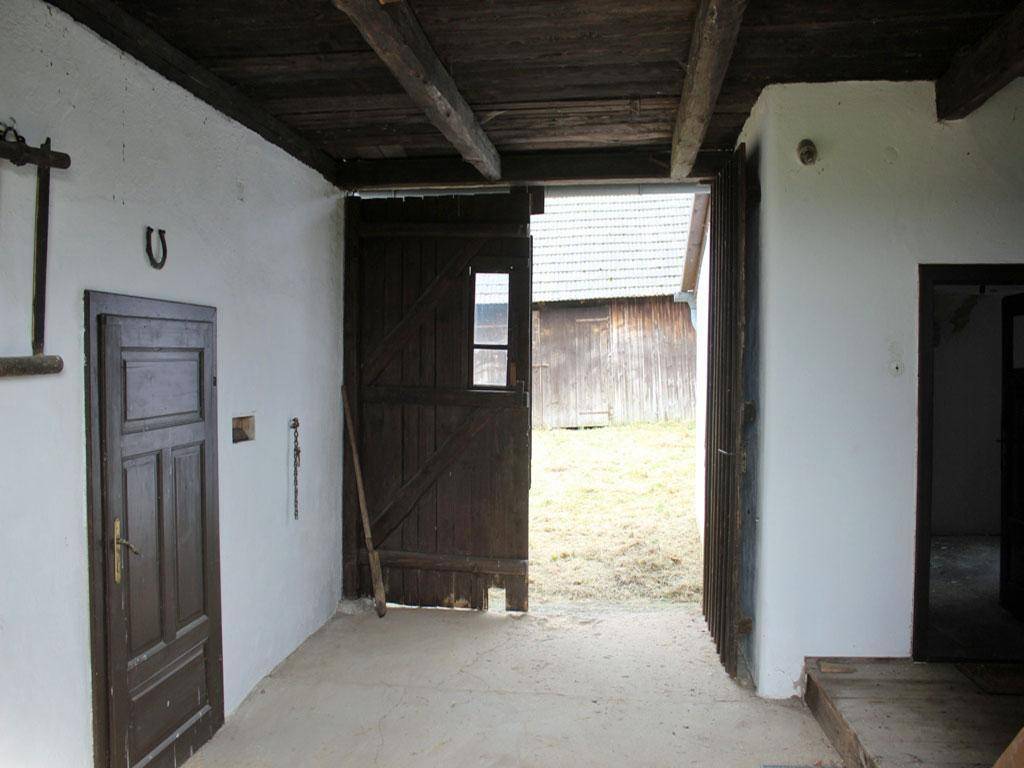 Rustikaler Eingangsbereich mit großen Holztüren und sichtbaren Holzbalken.