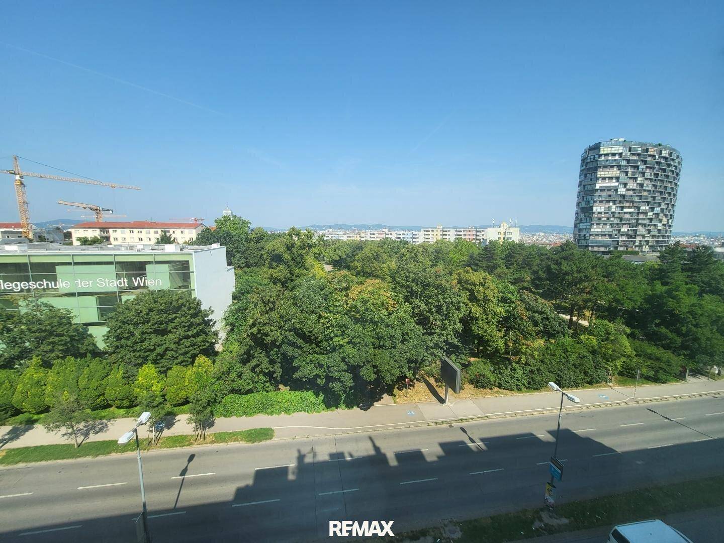 Weitläufiger Blick über die Stadt mit viel Grün und modernen Gebäuden.