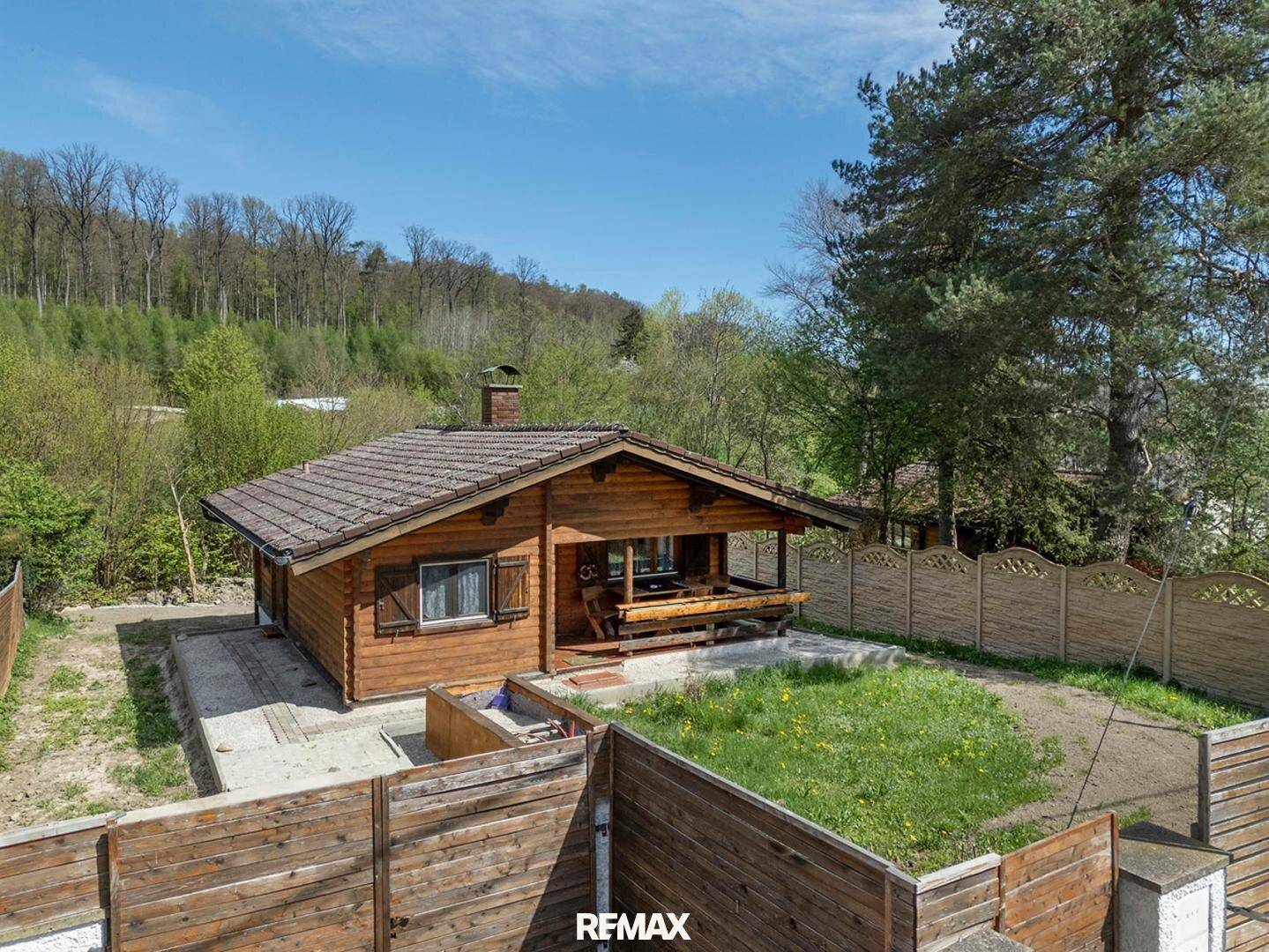 Charmantes Holzhaus mit Gartenbereich und umzäuntem Grundstück in ländlicher Umgebung.