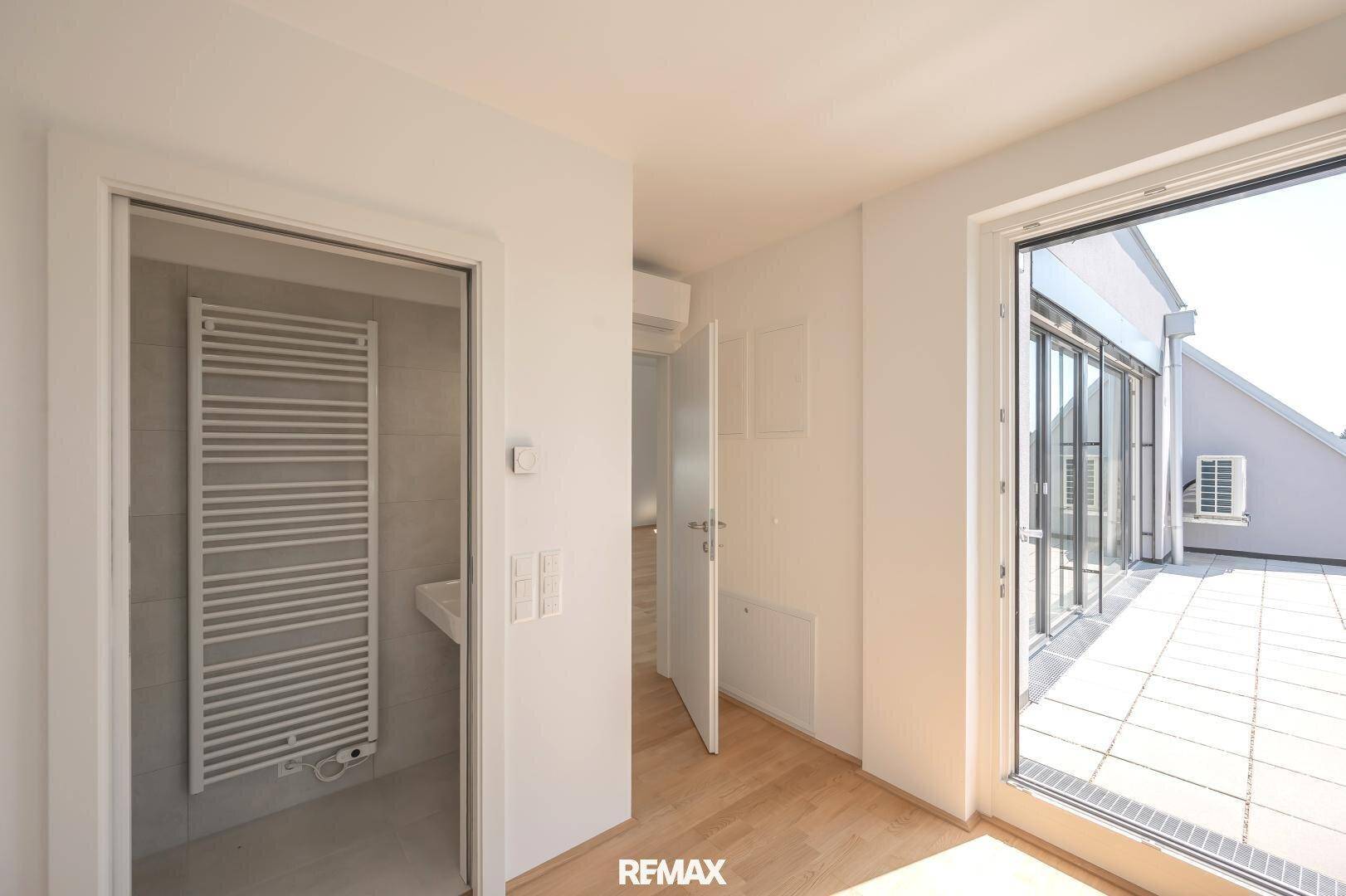 Heller Übergangsbereich mit Zugang zur Terrasse und einem beheizten Handtuchhalter, ideal für Komfort.