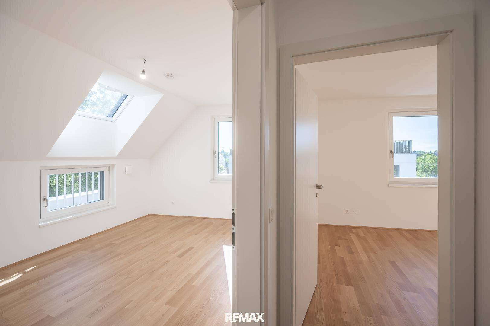 Helles Schlafzimmer mit Holzboden und Dachfenstern, bietet viel Tageslicht und eine ruhige Atmosphäre.