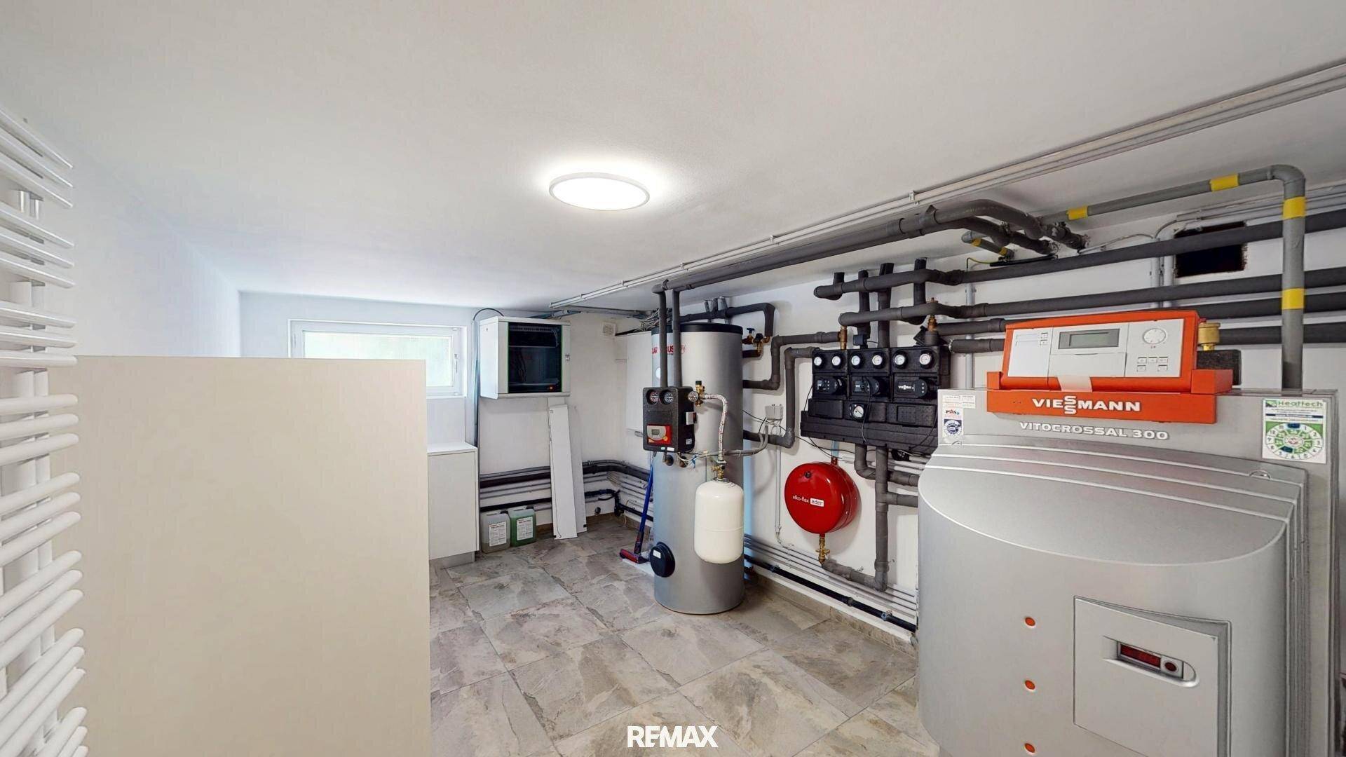 Technikraum mit moderner Viessmann Heizungsanlage, vielen Rohren und gefliestem Boden.