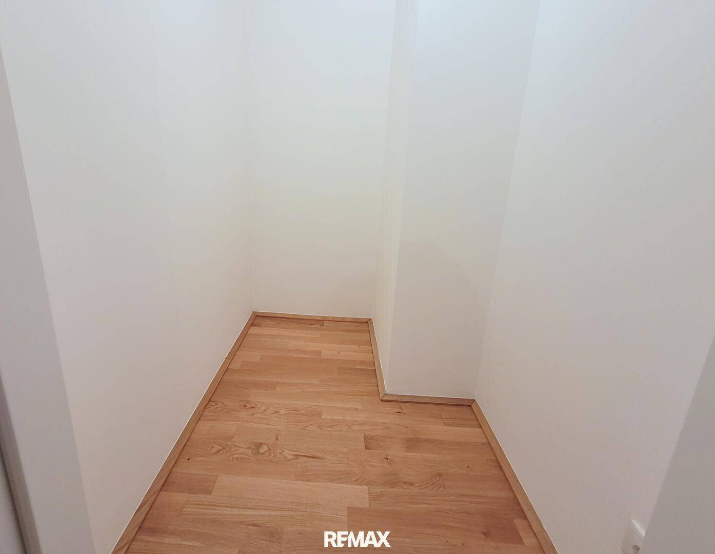 Kleiner Abstellraum mit Parkettboden und weißen Wänden, ideal für Lagerung oder als begehbarer Schrank.