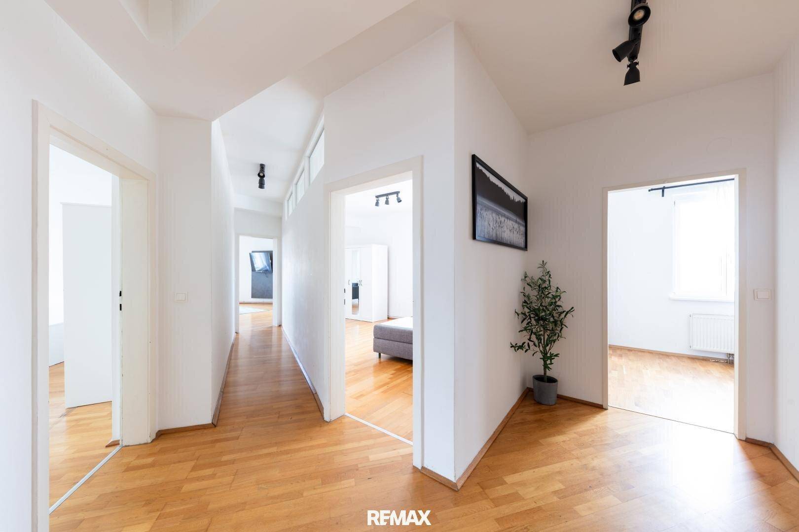 Geräumiger Flur mit Holzboden und Zugang zu verschiedenen Zimmern der Wohnung.