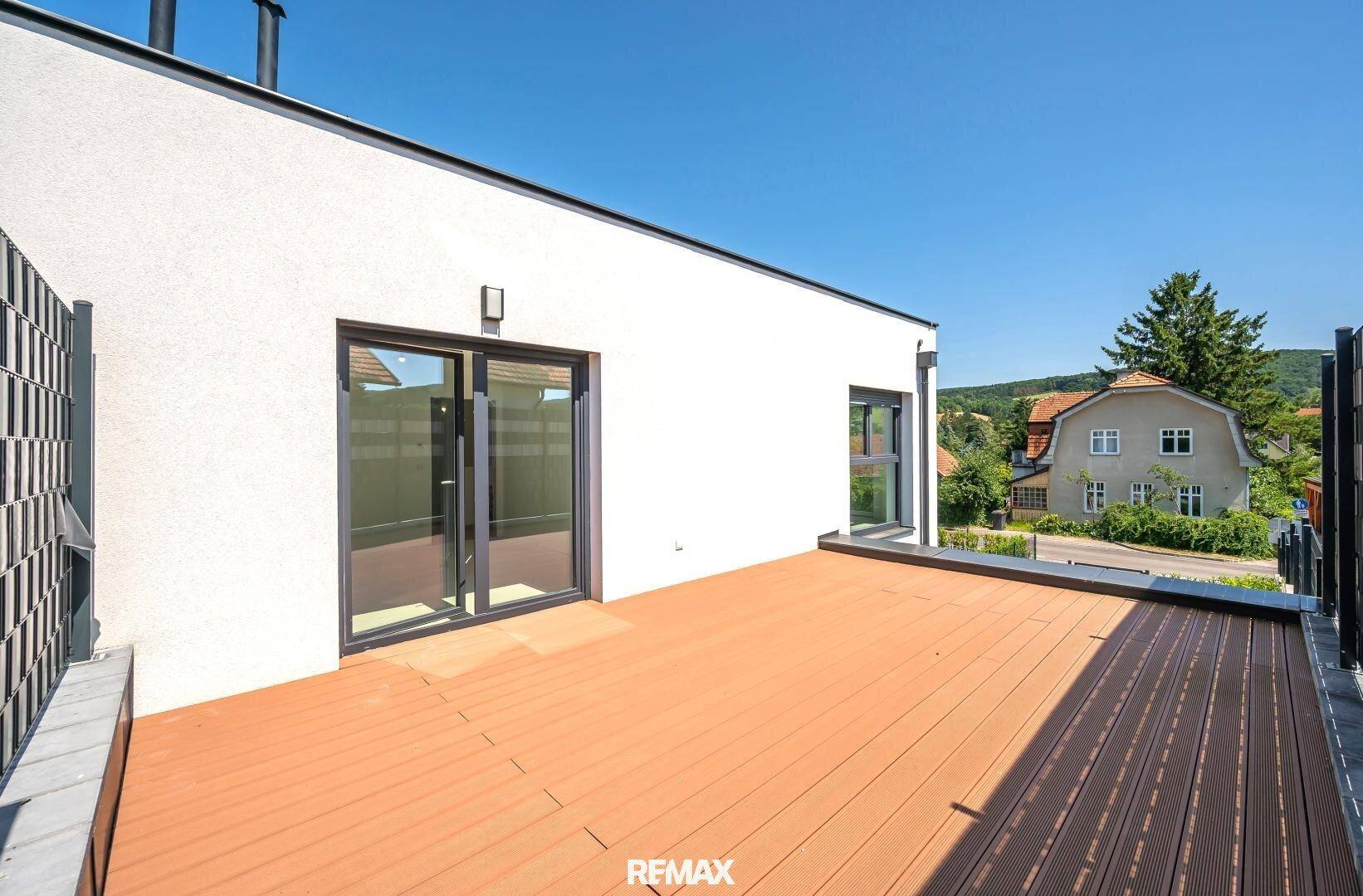 Geräumige Dachterrasse mit Holzboden und weitem Blick über die grüne Hügellandschaft.
