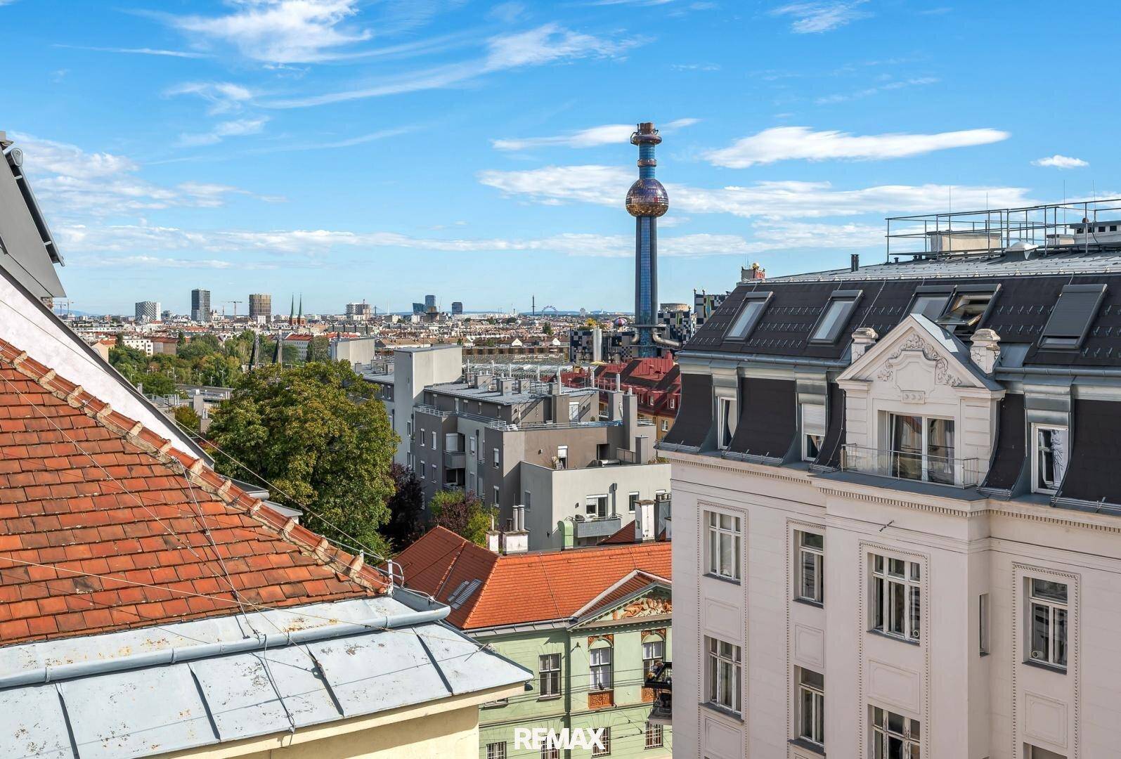 Panoramablick über die Stadt mit verschiedenen Gebäuden und einem markanten Turm am Horizont.