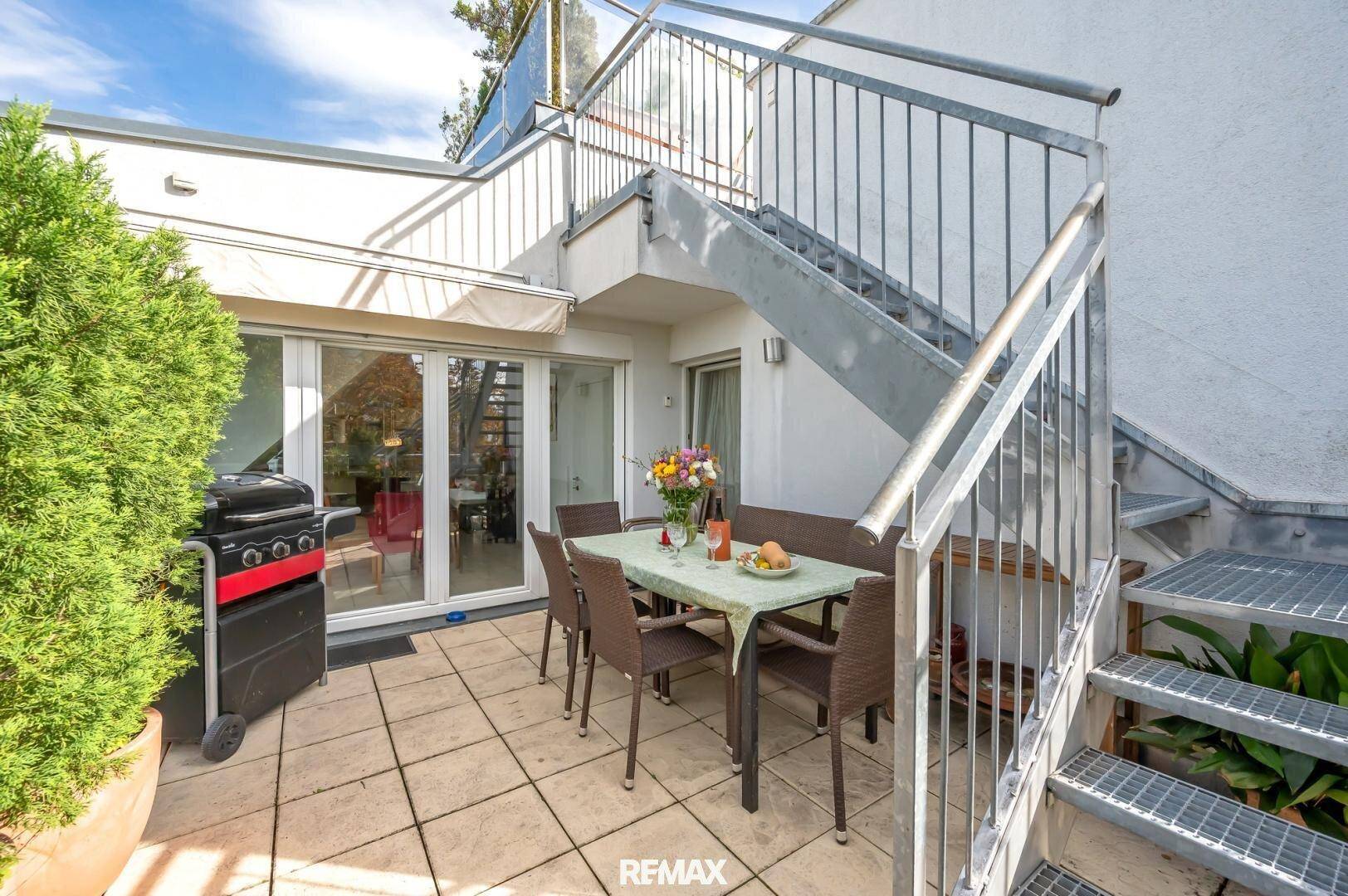 Geräumige Terrasse mit Essbereich im Freien, Grill und Außentreppe, perfekt für Sommerabende.
