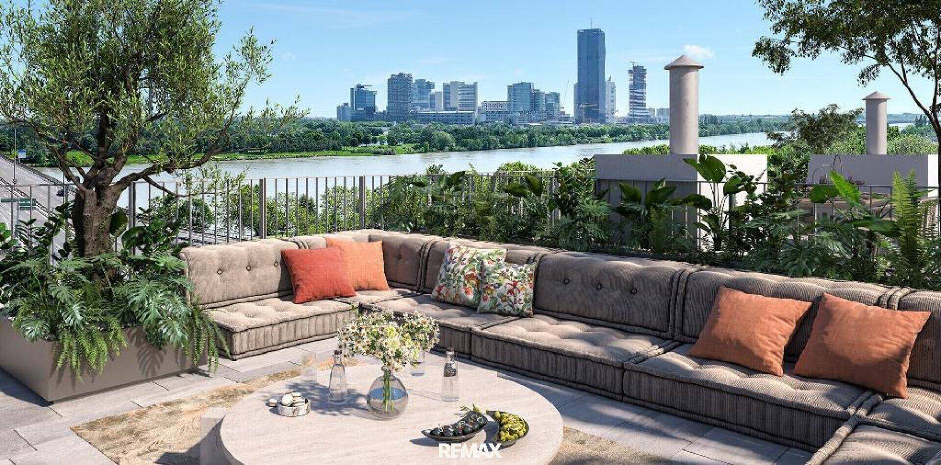 Geräumige Terrasse mit bequemen Lounge-Möbeln, Pflanzen und weitem Blick auf die Stadt und den Fluss.