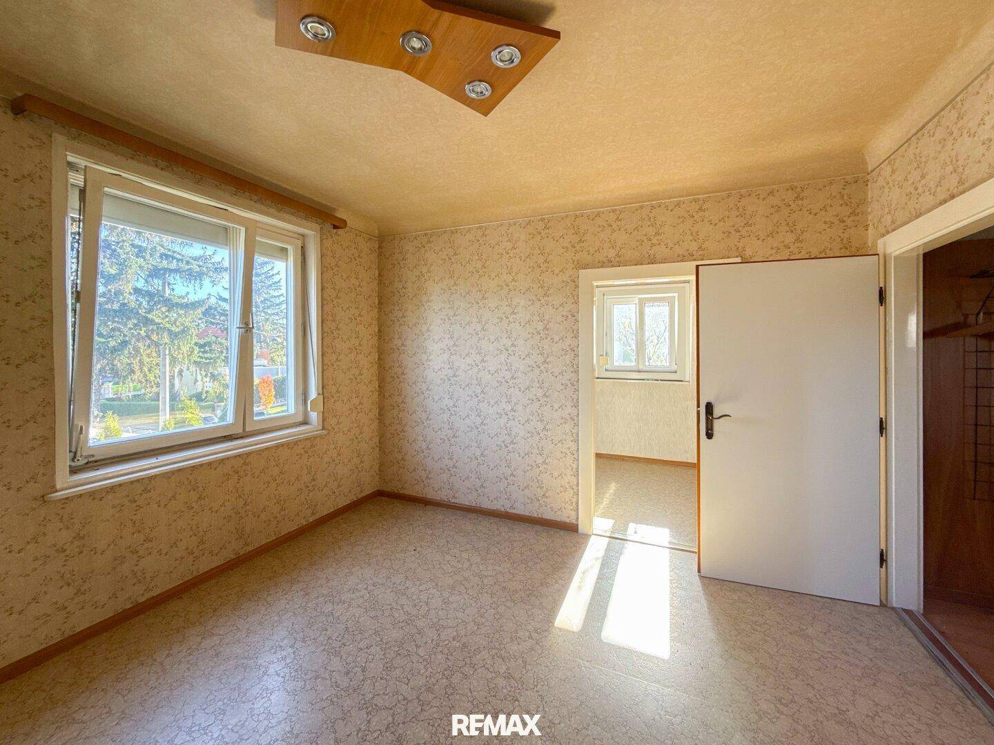 Geräumiges Zimmer mit Korkboden und Fenster, das viel Tageslicht hereinlässt und eine angenehme Atmosphäre schafft.