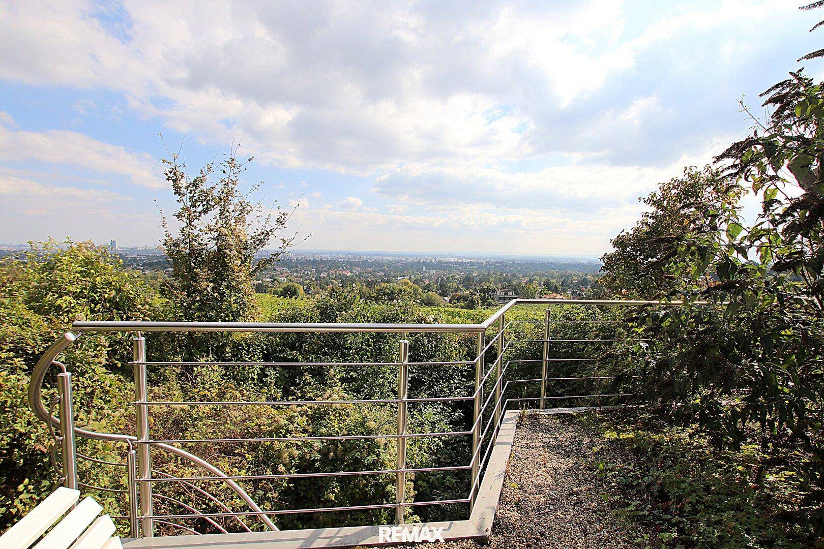 Ein Aussichtspunkt mit Metallgeländer bietet einen weiten Panoramablick über die Landschaft.