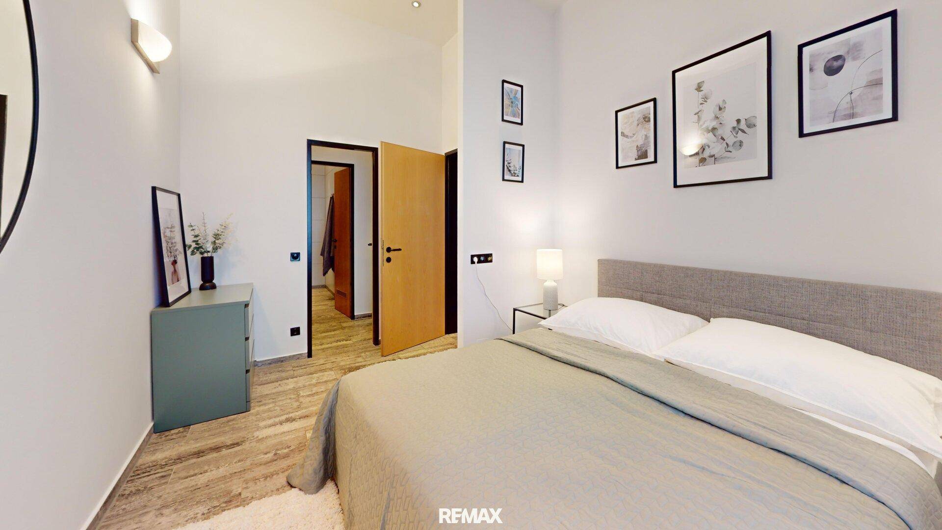 Modernes Schlafzimmer mit Zugang zu einem begehbaren Kleiderschrank und stilvoller Dekoration.