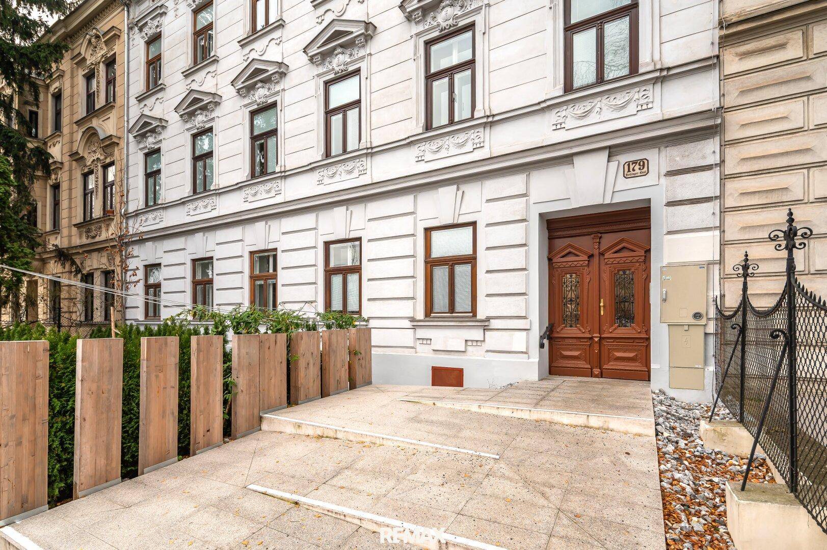 Historische Fassade eines Altbaus mit Holztür und gepflegtem Eingangsbereich.