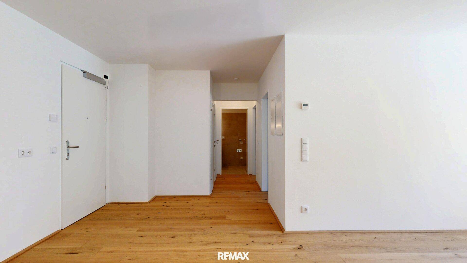 Heller Flurbereich mit Holzfußboden und mehreren Türen zu den angrenzenden Räumen.