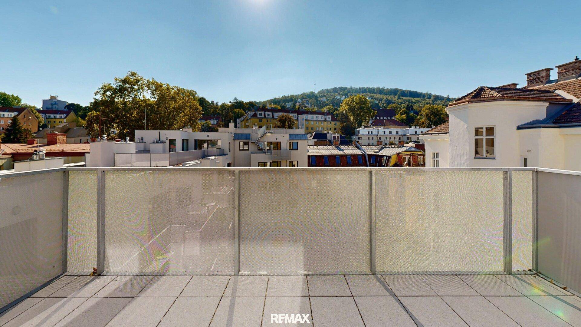 Geräumige Terrasse mit Blick auf die Stadt und die umliegenden grünen Hügel.