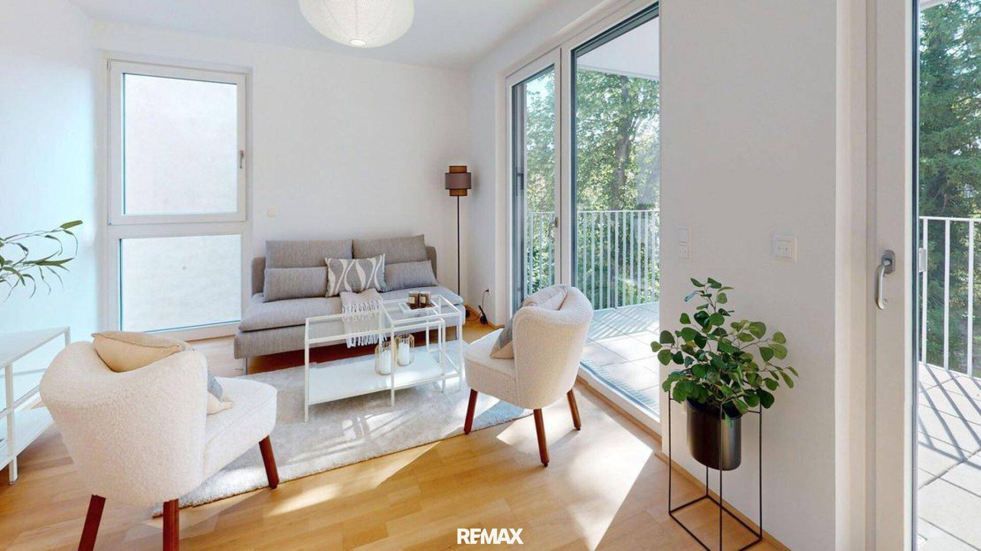 Gemütliches Wohnzimmer mit Zugang zum Balkon und großen Fenstern, die viel Licht hereinlassen.