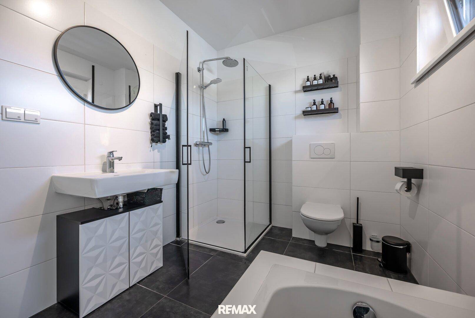 Stilvolles Badezimmer mit großer Dusche, Badewanne und modernem Waschtisch.