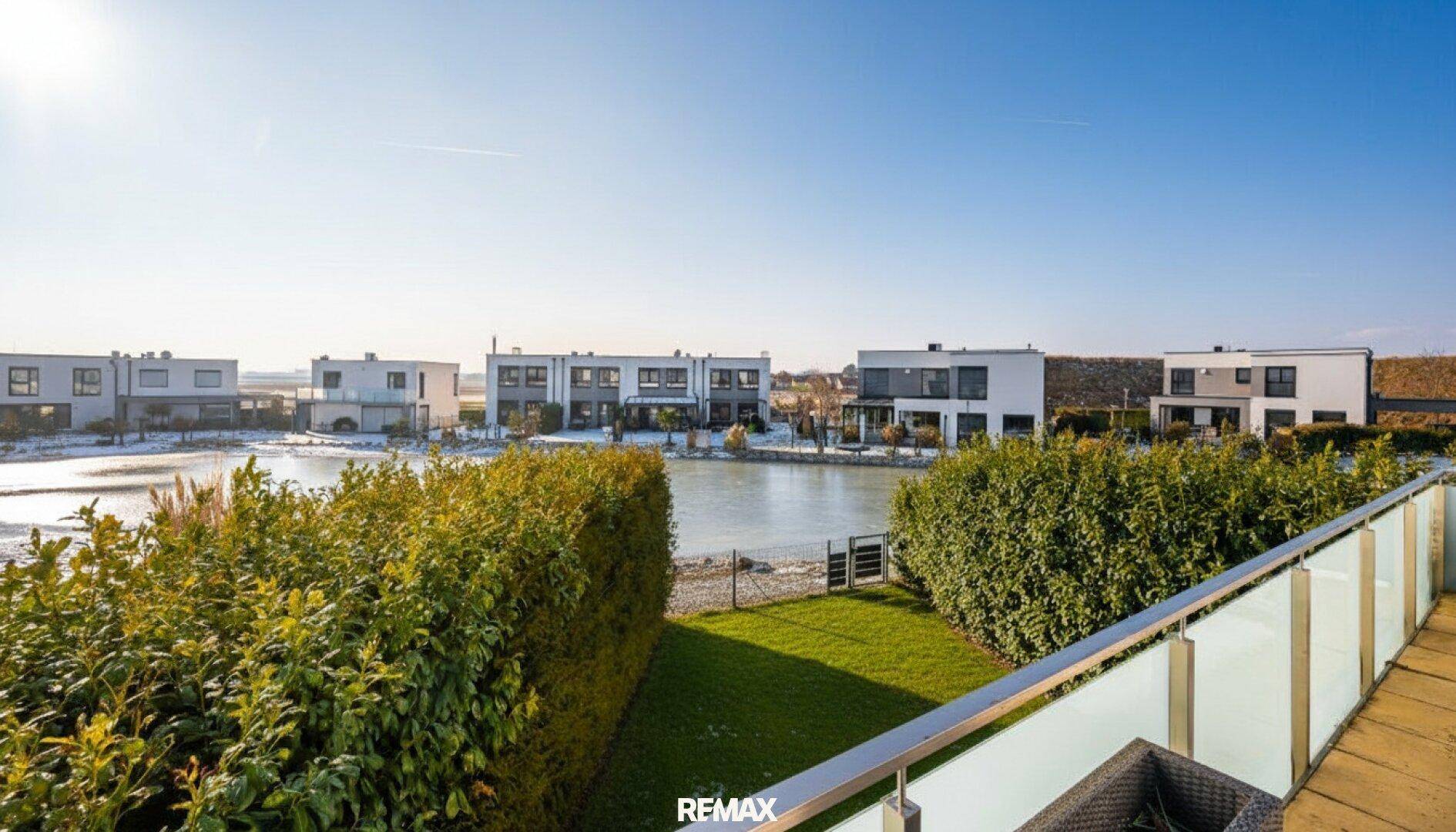 Balkon mit weitem Blick auf die umliegende Siedlung und den Teich.