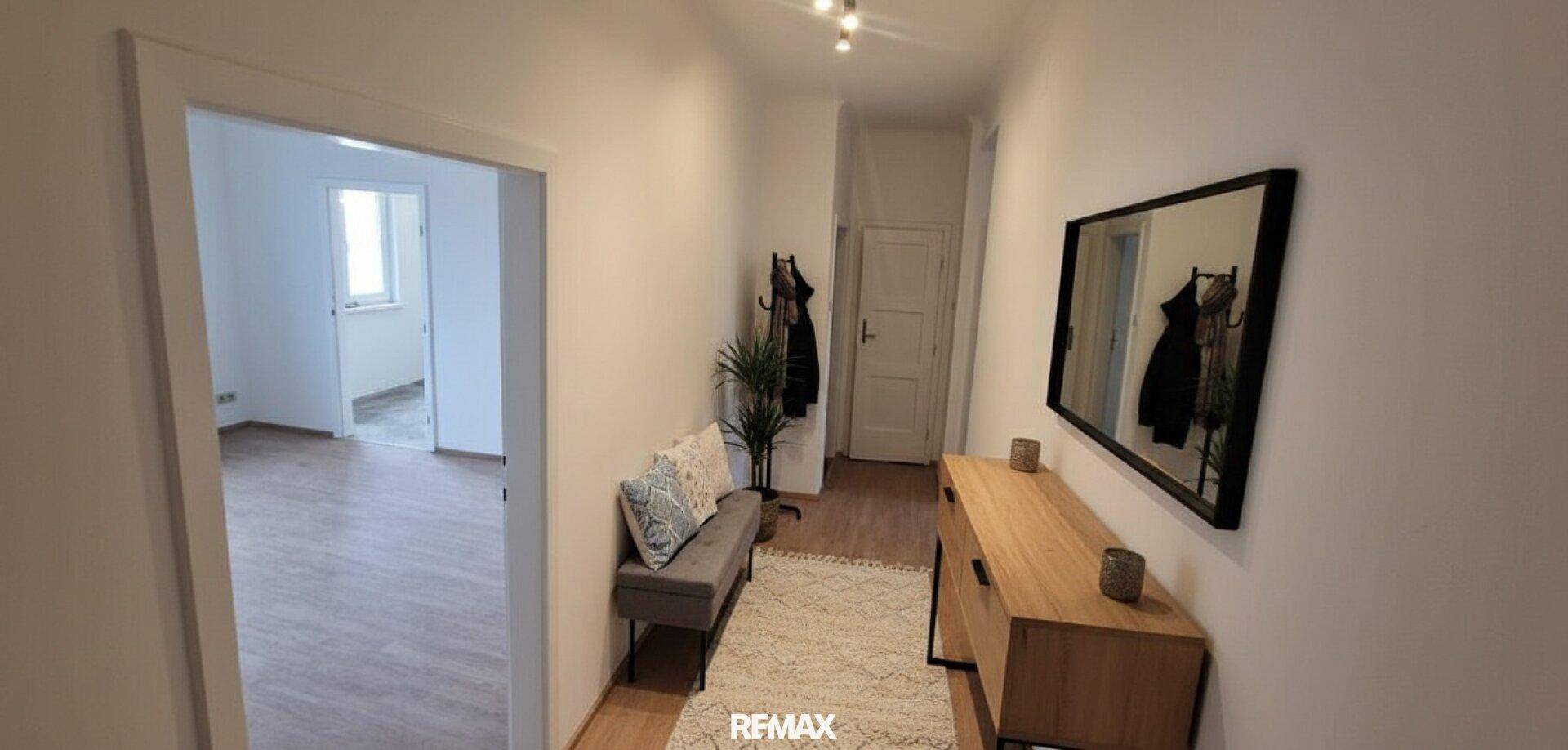 Heller Flur mit Garderobe, Spiegel und Sitzbank, verbindet die Wohnbereiche.