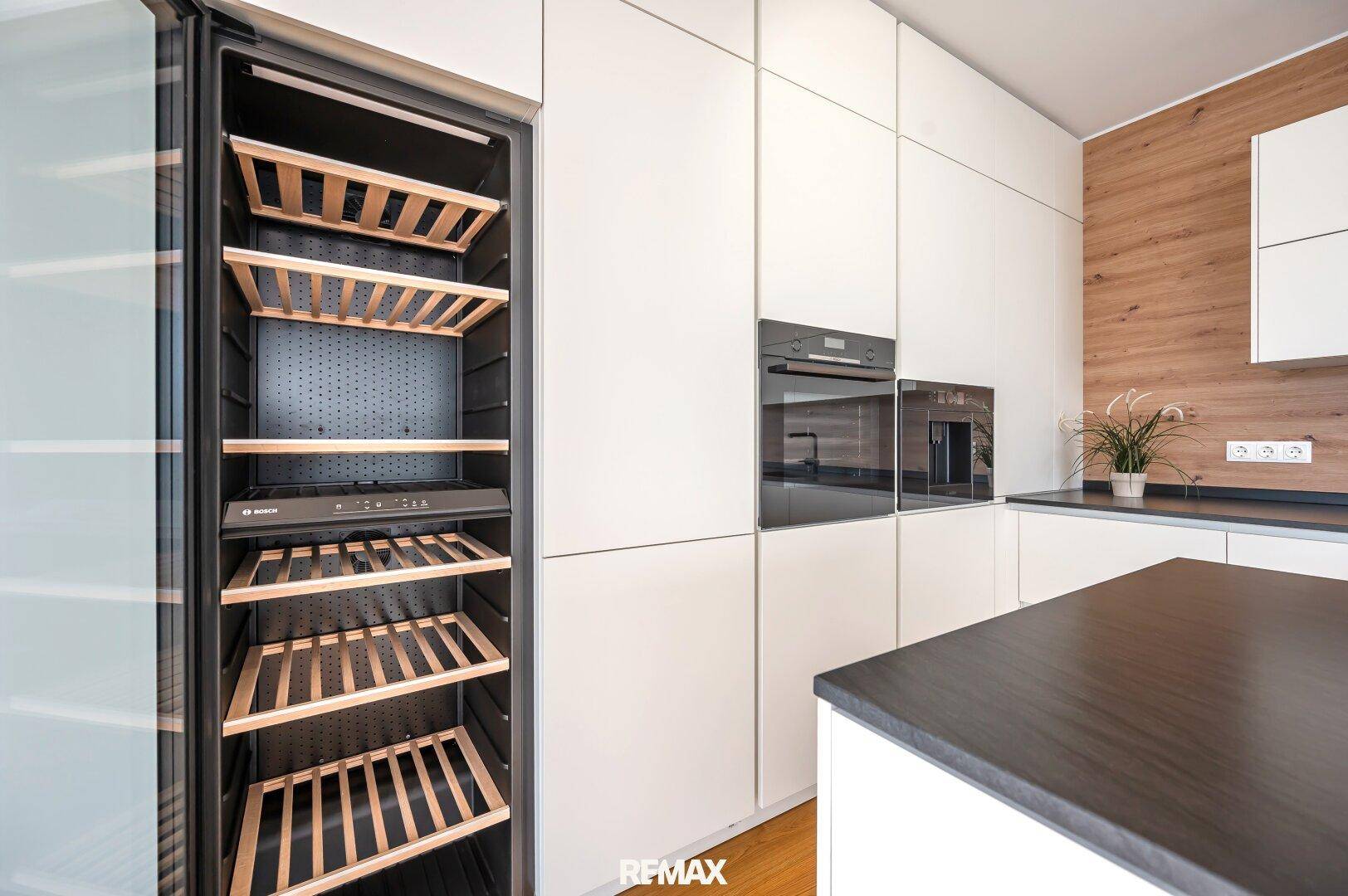 Integrierter Weinkühlschrank und Backofen in der modernen Küche mit hochwertigen Geräten.