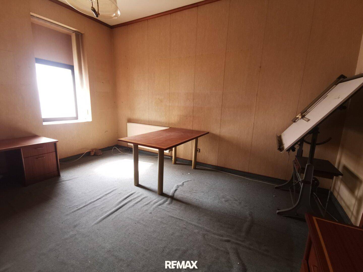 Arbeitszimmer mit einem Tisch, Zeichentisch und Fenster, bietet viel Tageslicht.
