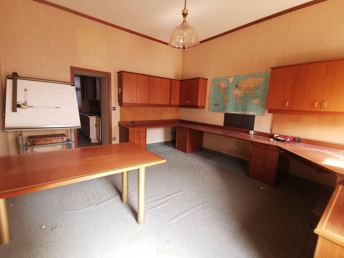 Büro mit Holzmöbeln, Teppichboden und einem Zeichentisch, bereit für kreative Arbeit.