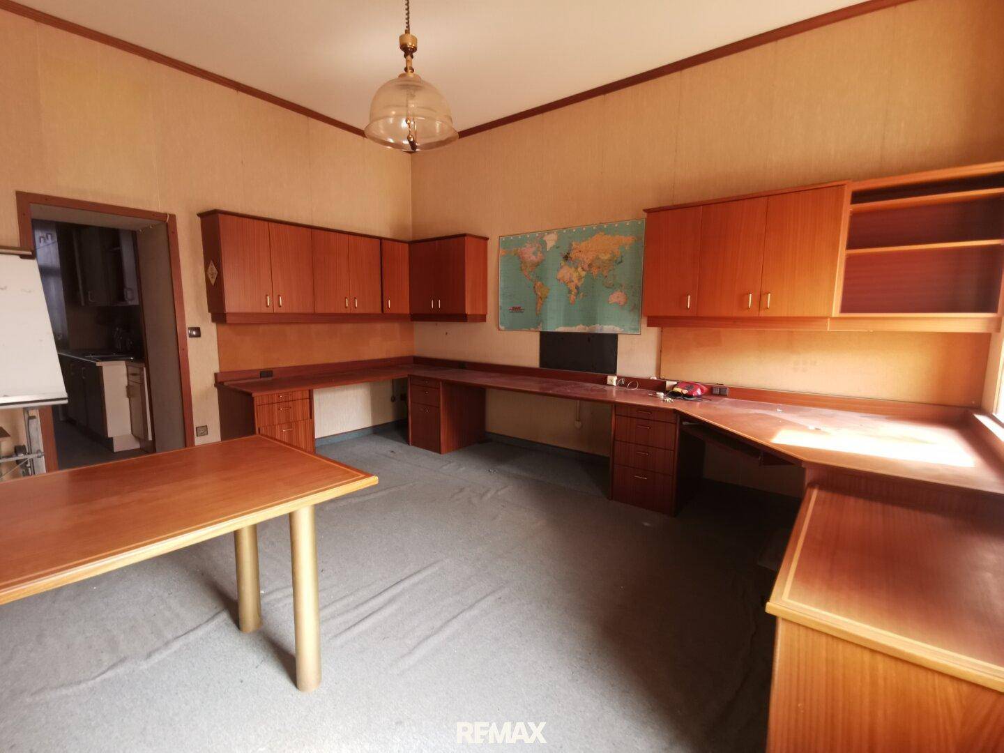 Arbeitszimmer mit umfangreichen Holzschreibtischen und Schränken, bietet viel Stauraum.
