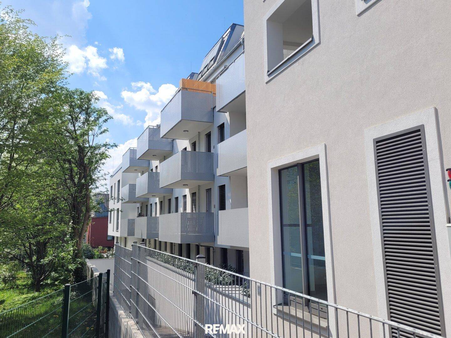 Moderne Wohnanlage mit mehreren Balkonen und barrierefreiem Zugang über eine Rampe.