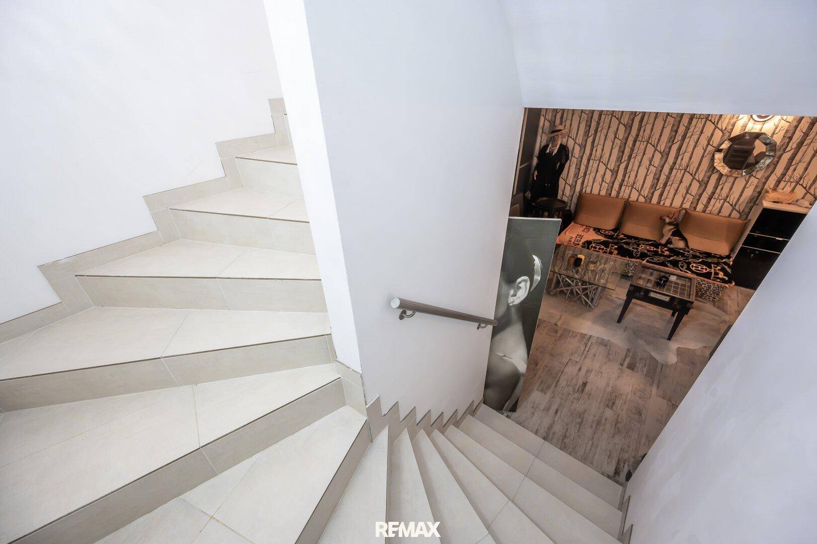 Moderne Treppe mit hellem Fliesenboden, die in einen stilvollen Wohnbereich führt.