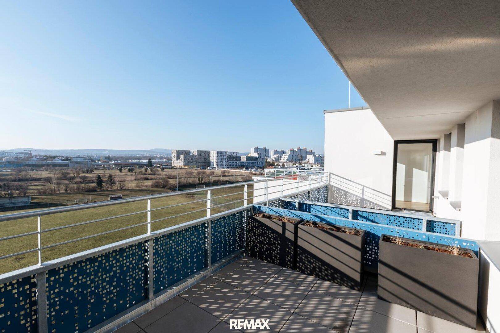 Geräumiger Balkon mit modernem Design, weitem Blick über die Stadt und viel Sonnenlicht.