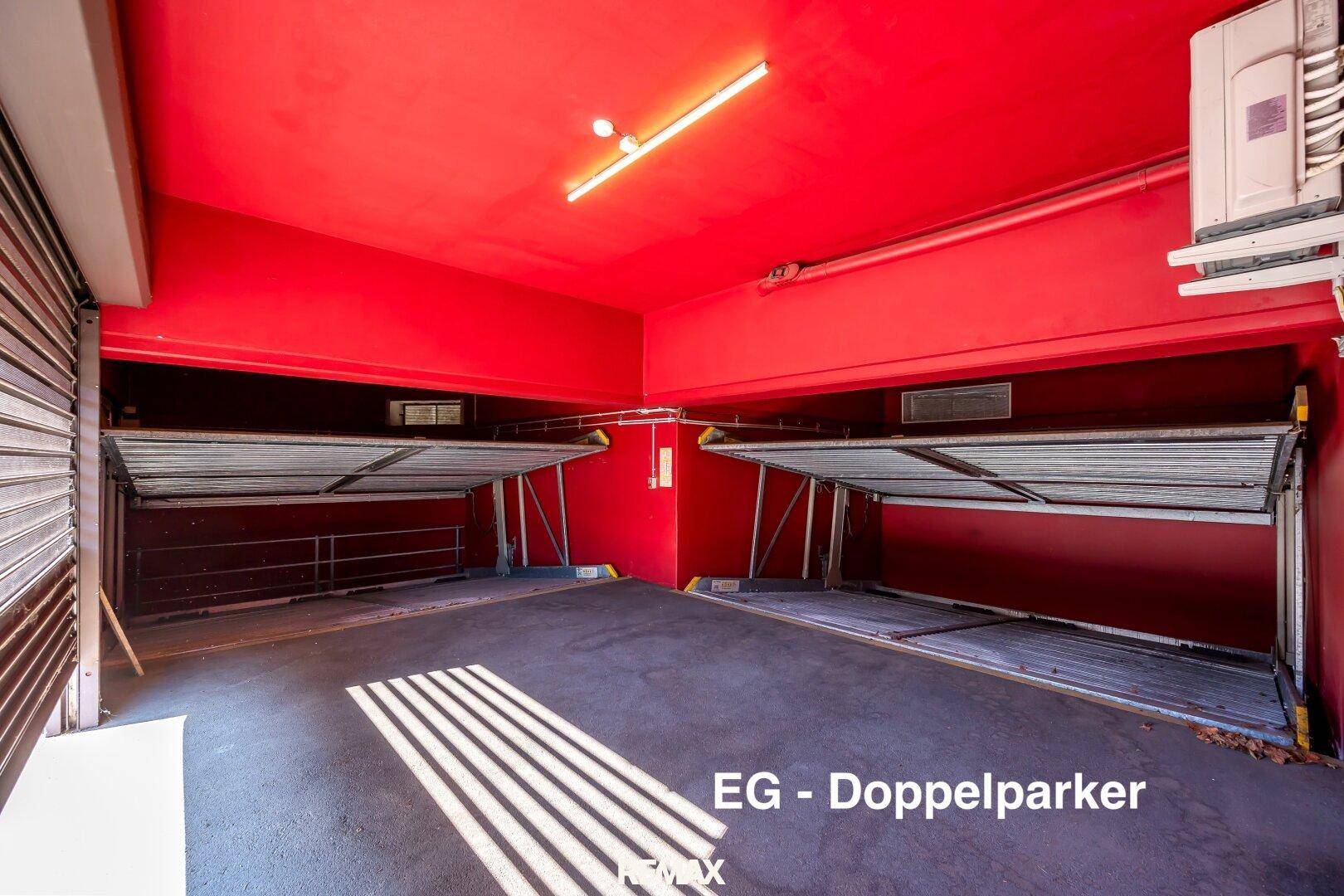 Tiefgarage mit Doppelparkern und roter Decke, bietet effiziente Parklösungen.