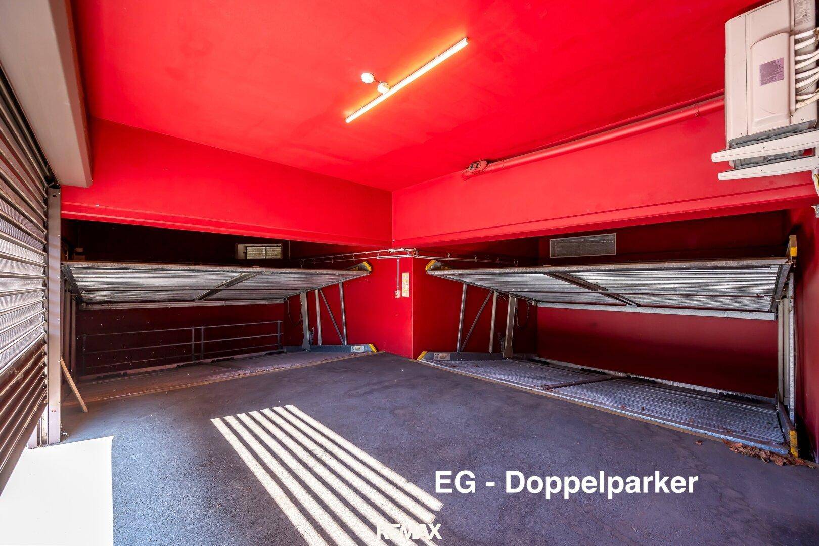 Doppelparker-Stellplätze in einer Tiefgarage mit auffällig roten Wänden und Decken.