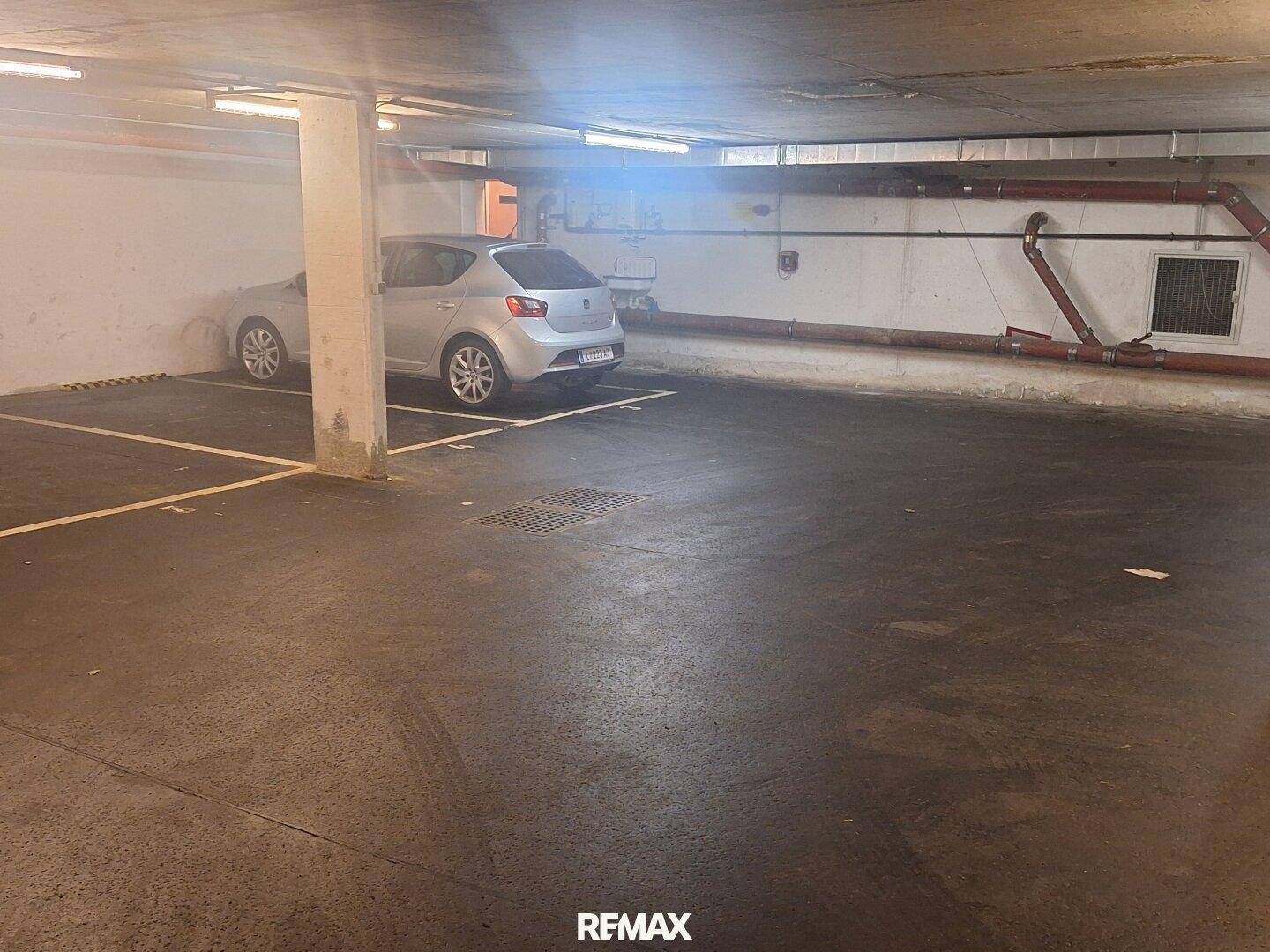 Tiefgarage mit einem geparkten Auto und ausreichend Platz für weitere Fahrzeuge.