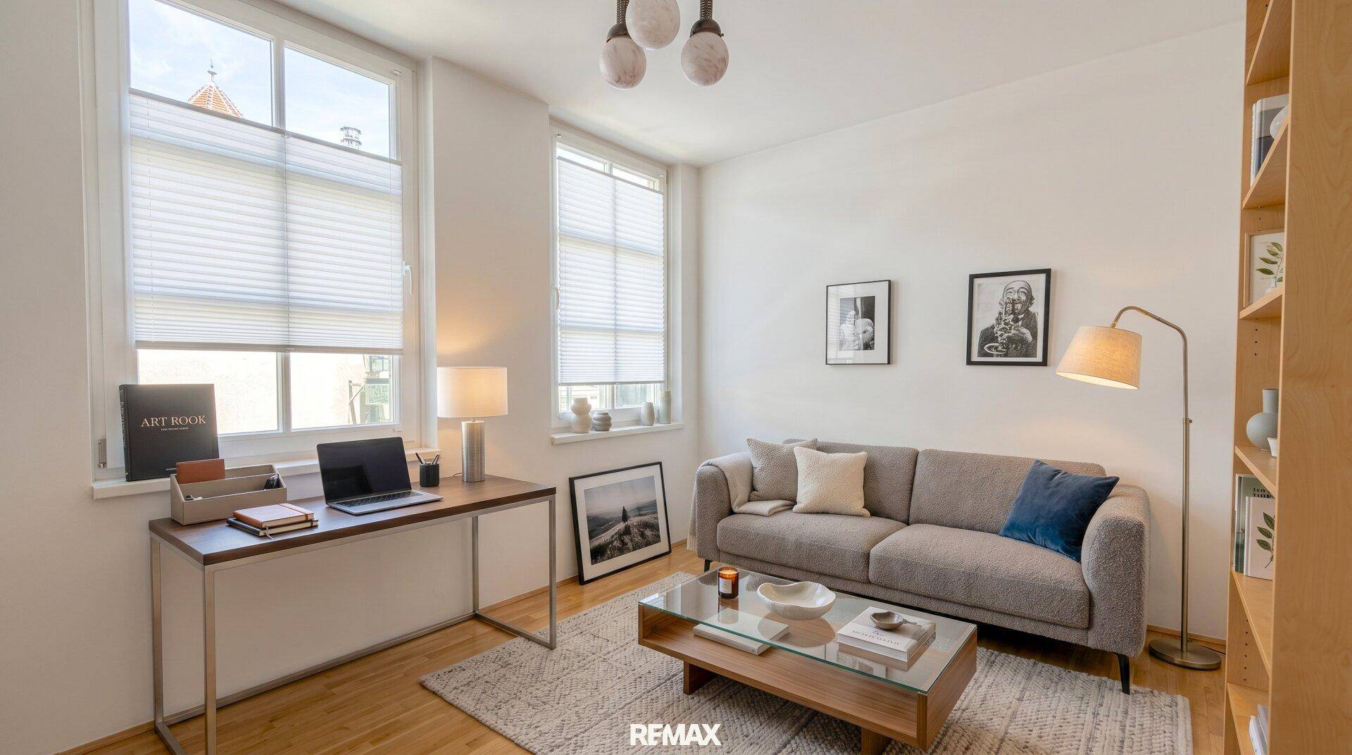 Helles Arbeitszimmer mit Schreibtisch, Sofa und großen Fenstern, die viel Tageslicht bieten.