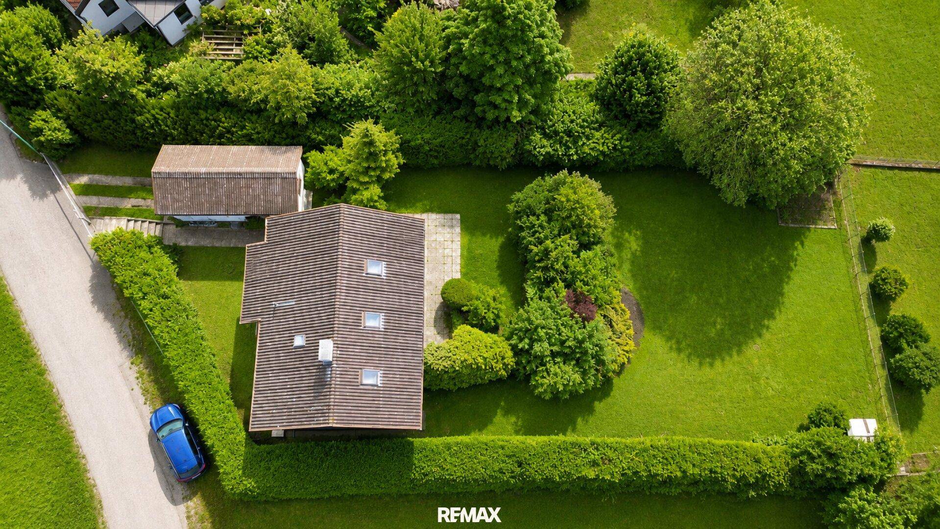 Vogelperspektive des Hauses mit großem Garten, gepflegtem Rasen und dichter Hecke.