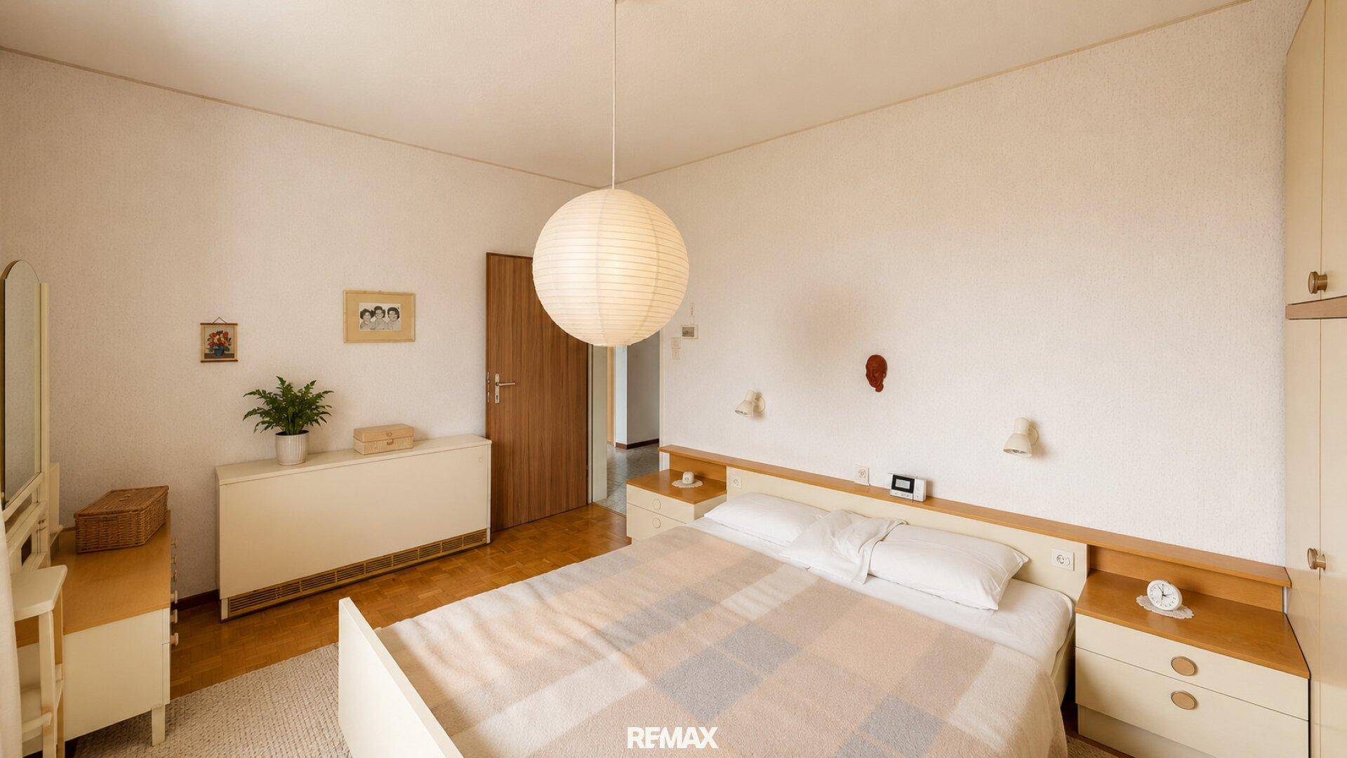 Gemütliches Schlafzimmer mit Doppelbett, Nachttischen und einem großen Kleiderschrank.