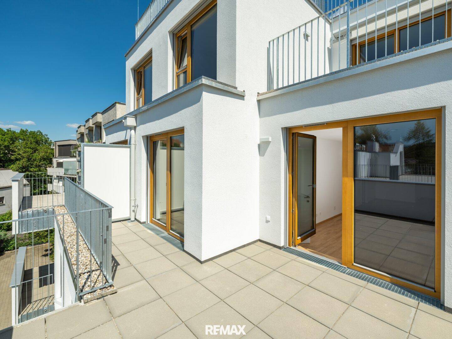 Sonniger Balkon mit Fliesenboden und Metallgeländer, bietet einen schönen Ausblick.