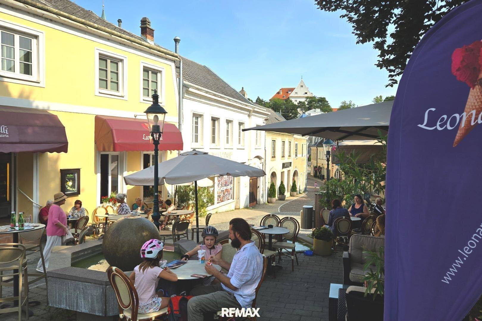 Belebte Straßenszene mit Außencafés, Menschen und traditionellen Gebäuden in der Altstadt.