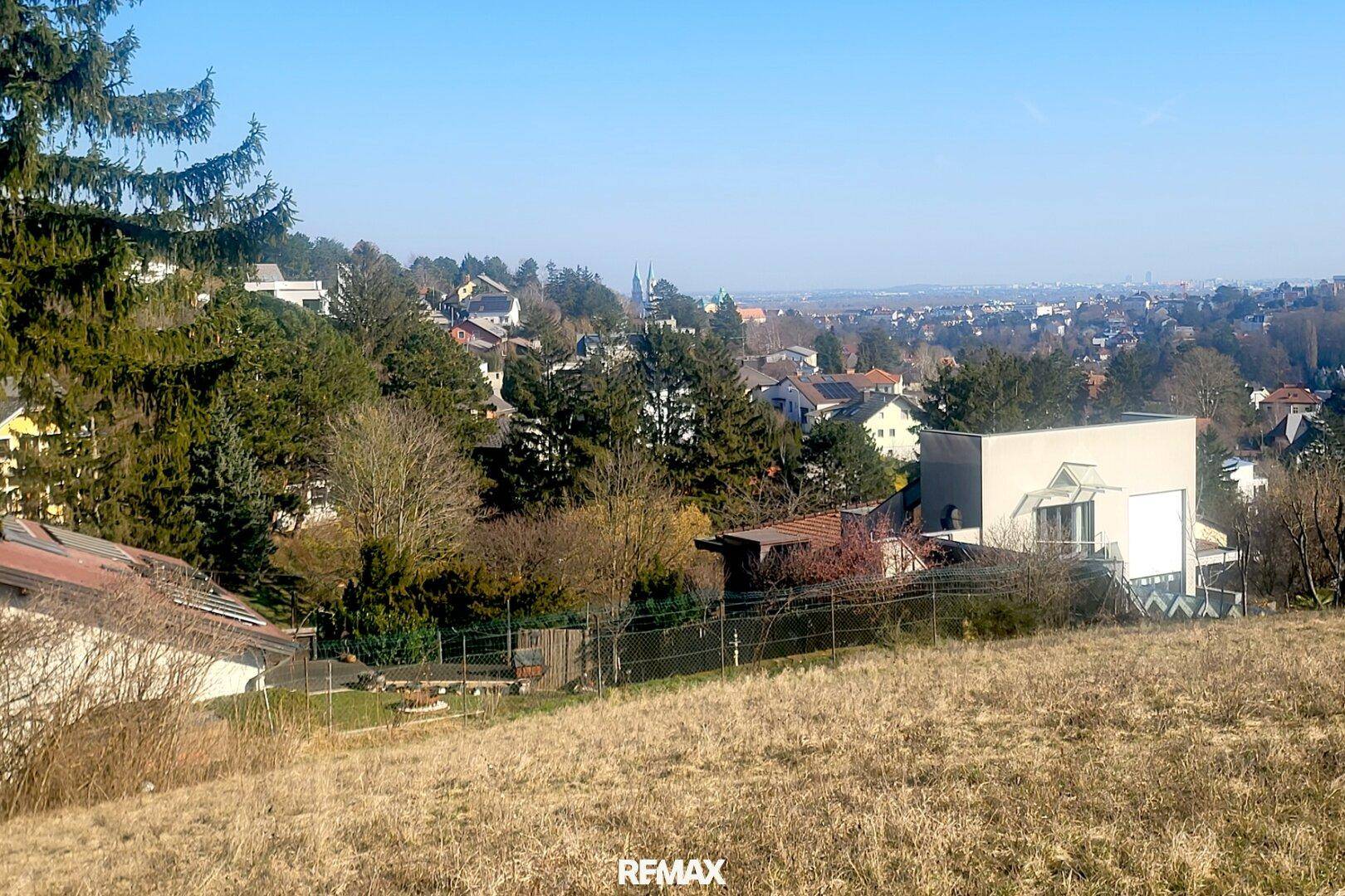 Weitläufiger Panoramablick über die Stadt und die umliegende Landschaft von einem Hügel aus.