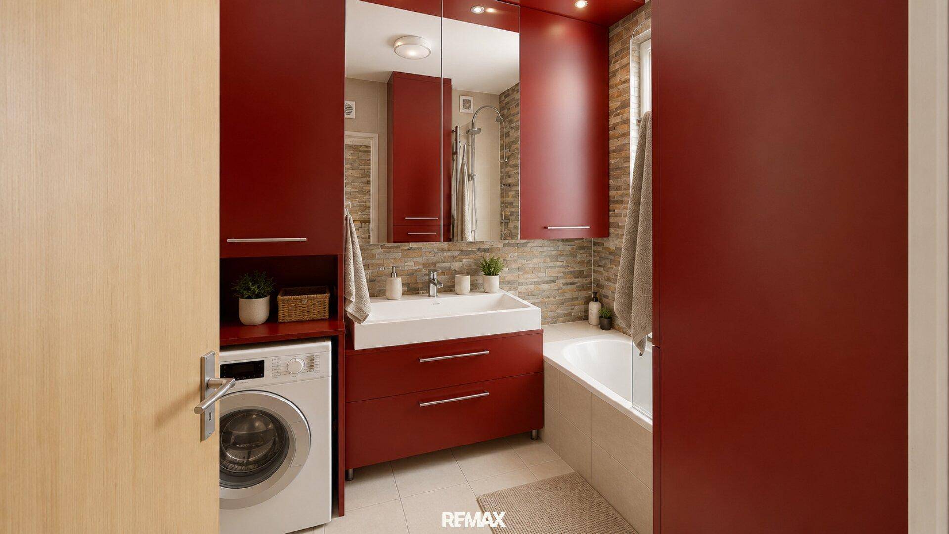 Funktionales Badezimmer mit Waschmaschine, Waschbecken, Badewanne und roten Schränken.