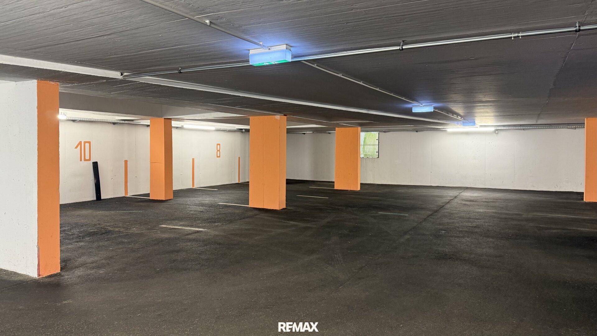 Weitläufige Tiefgarage mit zahlreichen nummerierten Stellplätzen und guter Beleuchtung.