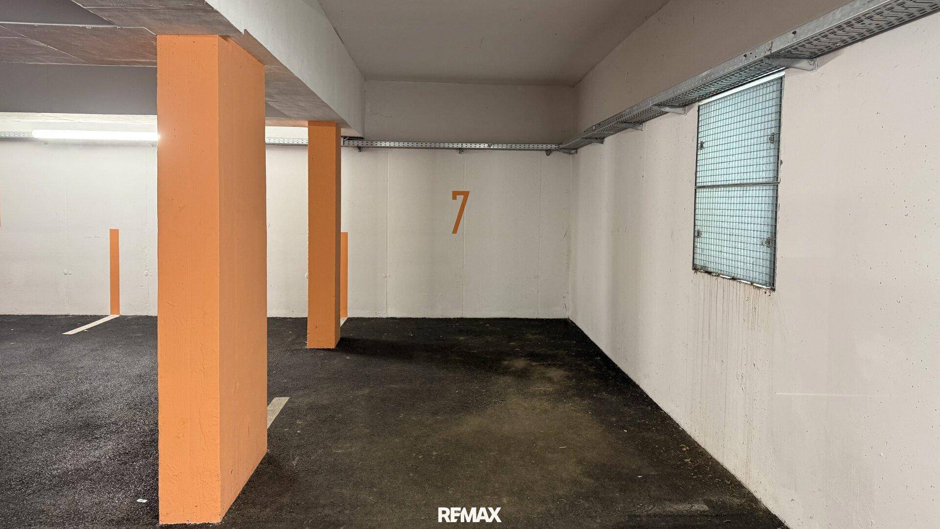 Einzelner Parkplatz Nummer 7 in der Tiefgarage, mit einem Fenster für Tageslicht.