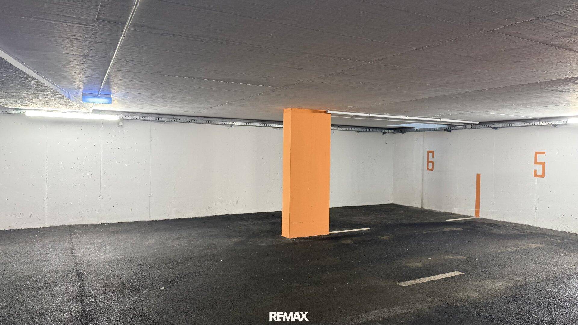 Weiterer Blick in die Tiefgarage mit nummerierten Parkplätzen und einer stabilen Säulenkonstruktion.