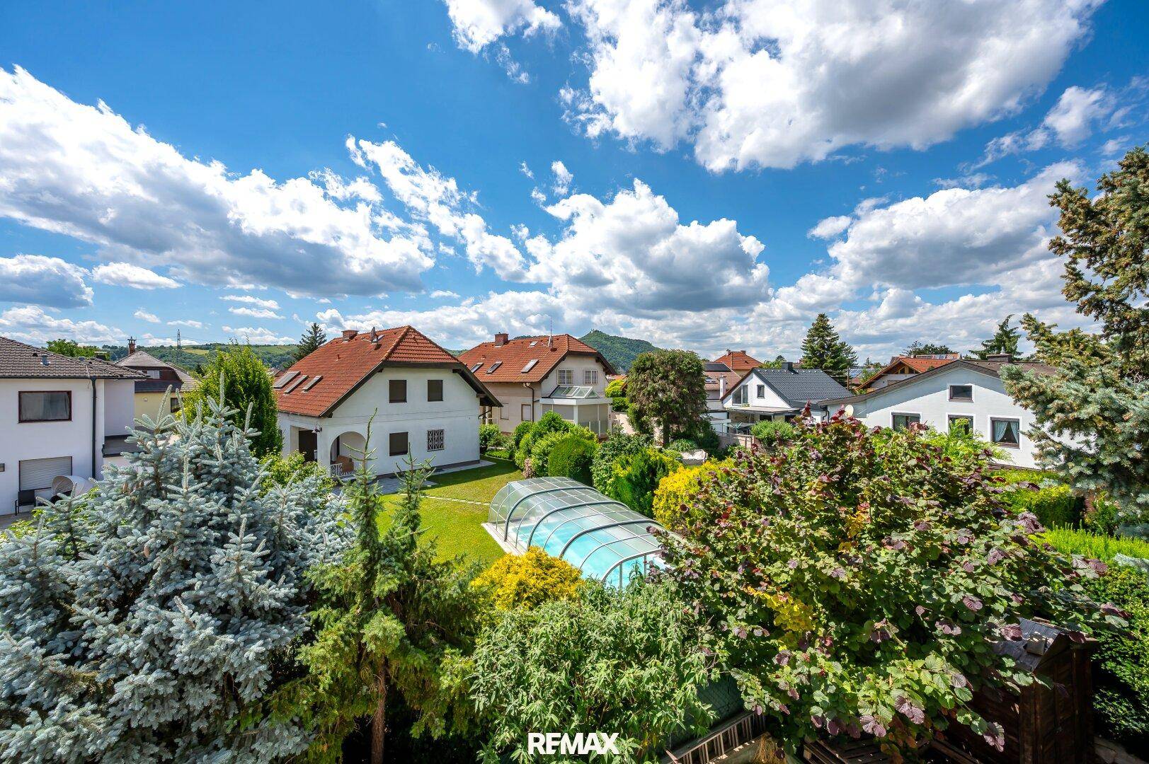 Weitläufiger Blick über die Nachbarschaft mit Häusern, Gärten und einem Pool.